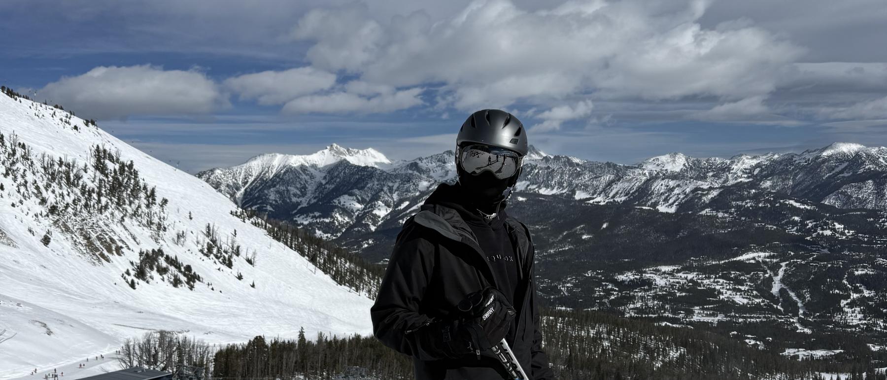 Charlie on skis high on a Montana slope, peaks in the distance