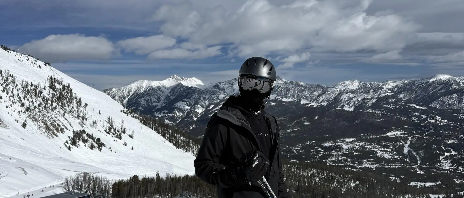 Charlie on skis high on a Montana slope, peaks in the distance